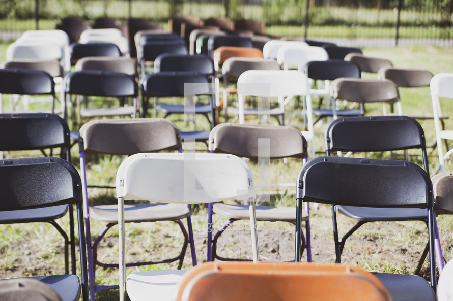 rows of folding chairs in a lawn 