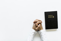 praying hands and open Bible 