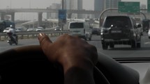 Christian man driving in his car in Dubai on his commute to work on a busy highway during rush hour traffic.