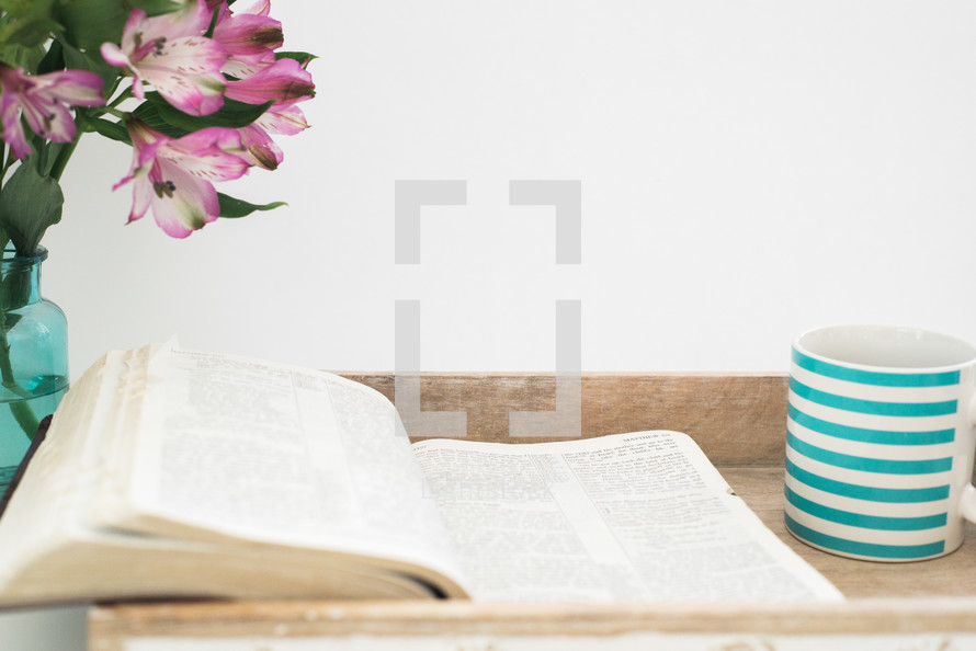 vase of flowers and open Bible sitting in a tray 