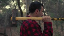 Criminal Mad man walks with hatchet and breaks a tree in the forest
