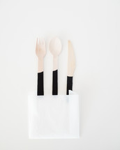 wooden fork, spoon, and knife in a napkin 