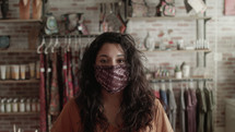 a woman in a boutique wearing a face mask 