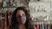a woman at a boutique wearing a face mask 