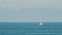 Sail boat in the middle of the calm ocean