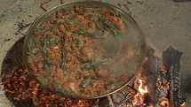 Top view of a valencian paella with chicken and rabbit meat, garnished with sprigs of thyme, on a large skillet. In honor of the Fallas celebration in Valencia, Spain