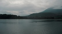 Lake Atitlan Surrounded By Mountains In Sunrise - Cloudy Day At The Lake In Guatemala - aerial drone shot	