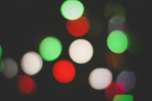 red, green, and white bokeh Christmas lights in darkness
