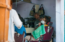man getting a shave at a barber in Mandawa, India 