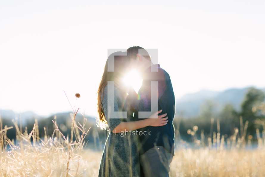 couple hugging outdoors and a sunburst 