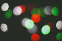 green, red, and white bokeh Christmas lights in darkness