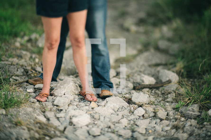 a couple standing on rocks outdoors 