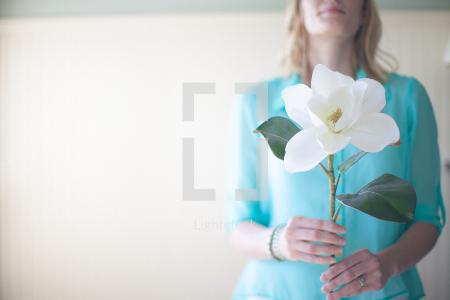 woman holding a magnolia flower