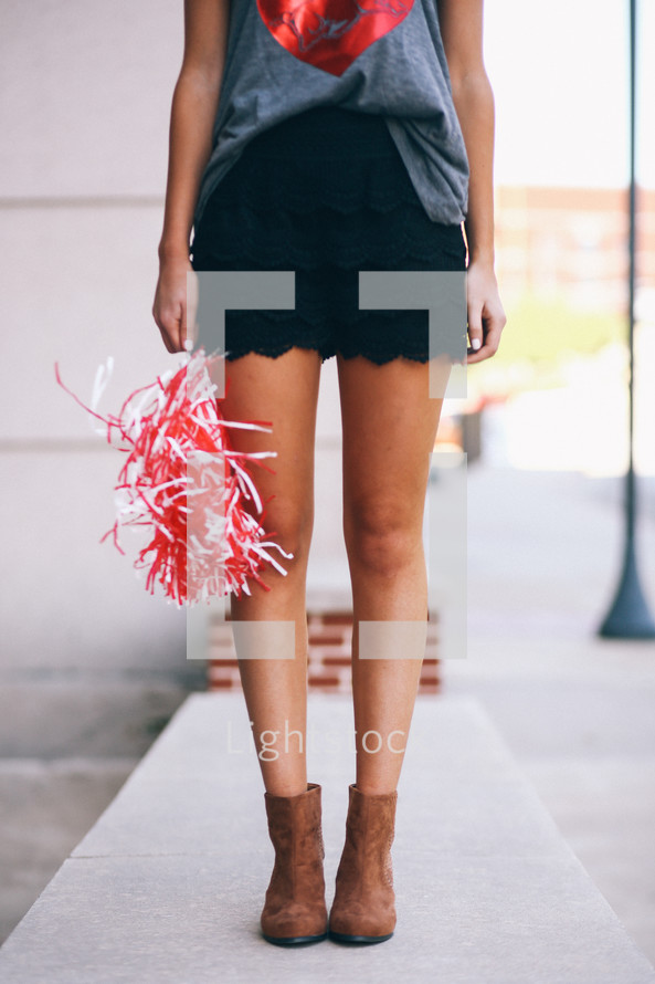 legs of a teen girl holding a pom pom 
