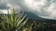 Scenic view of a mountain in Indonesia with foliage in front and clouds in the sky