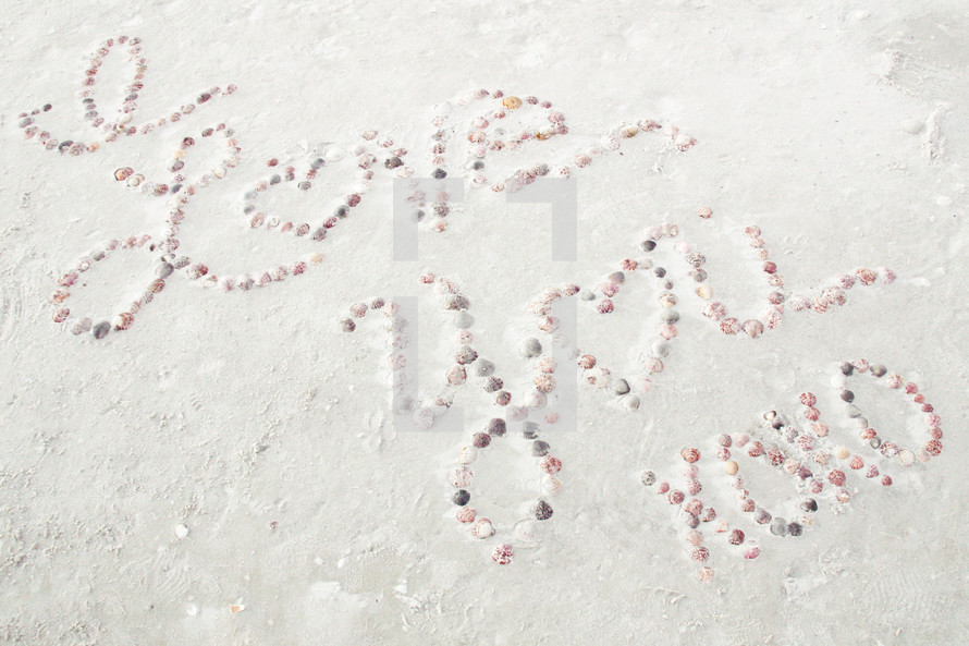 "I Love You XOXO" seashell message on beach sand