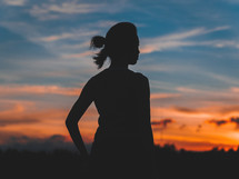 silhouette of a woman outdoors at sunset 