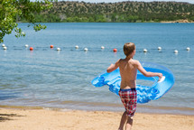 a boy with a float on a beach 
