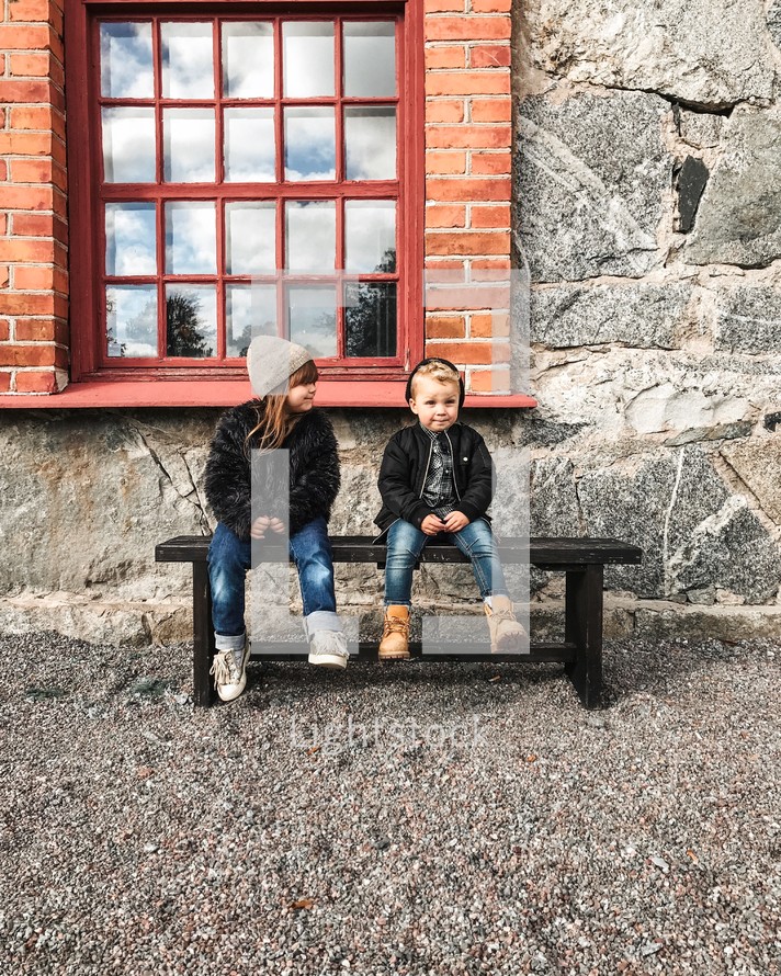 boy and girl sitting on a bench 
