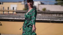 Woman twirling in a dress on a rooftop.