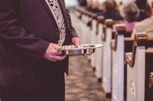 men ushers holding offering plates during a Sunday morning worship service 
