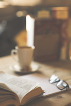 a notebook, reading, and open Bible on a desk 