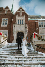 bride and groom on church stairs in the snow 