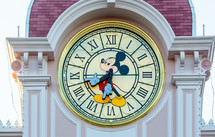 Paris, France - June 02, 2023: Mickey mouse clock tops the hotel at the Disneyland park entrance.
