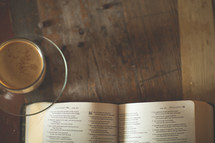 a coffee and open Bible on a table 