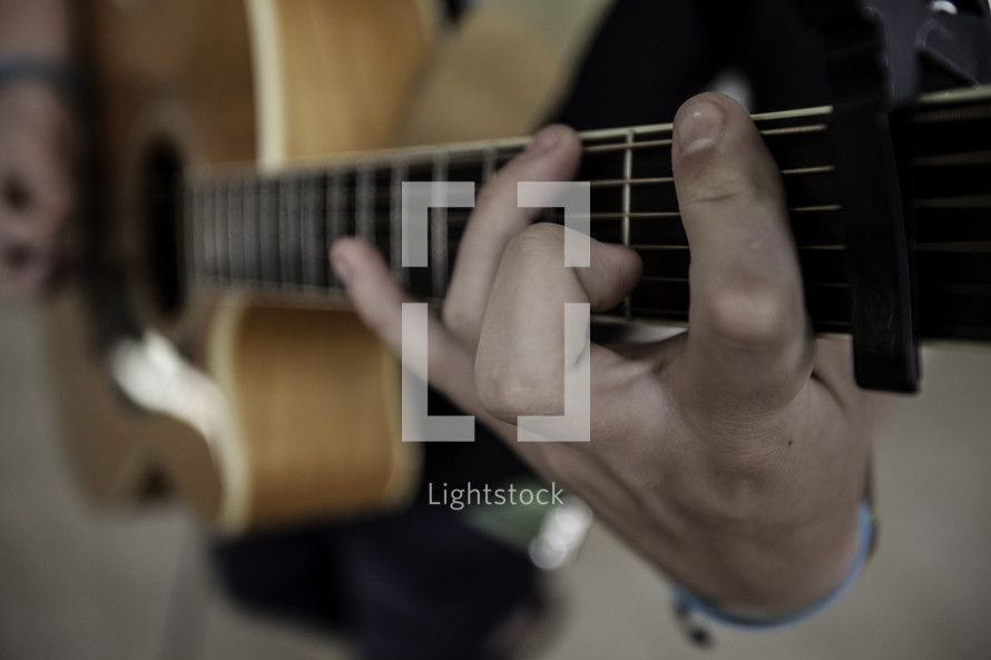 Man's finger playing guitar