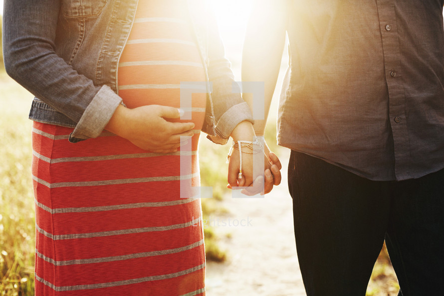 pregnant woman and man holding hands