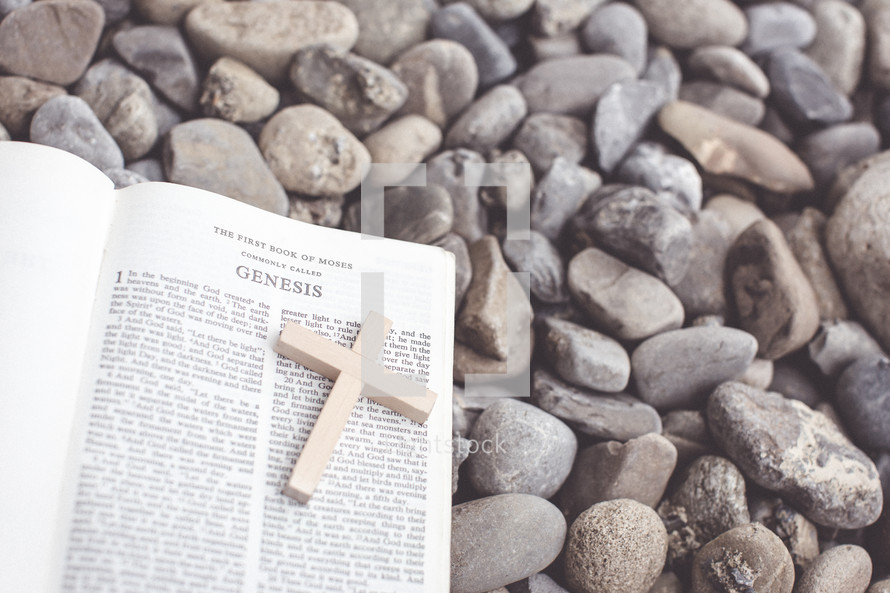 Bible open to Genesis lying on pebbles 