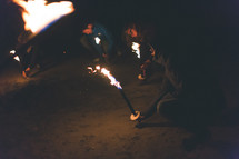 A group of people with burning torches at night.
