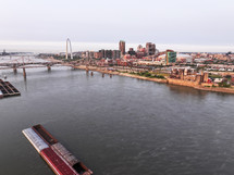 Aerial photo over the Mississippi River looking into a view of downtown Saint Louis, Missouri city on a clear sky day with bridges and skyscrapers.