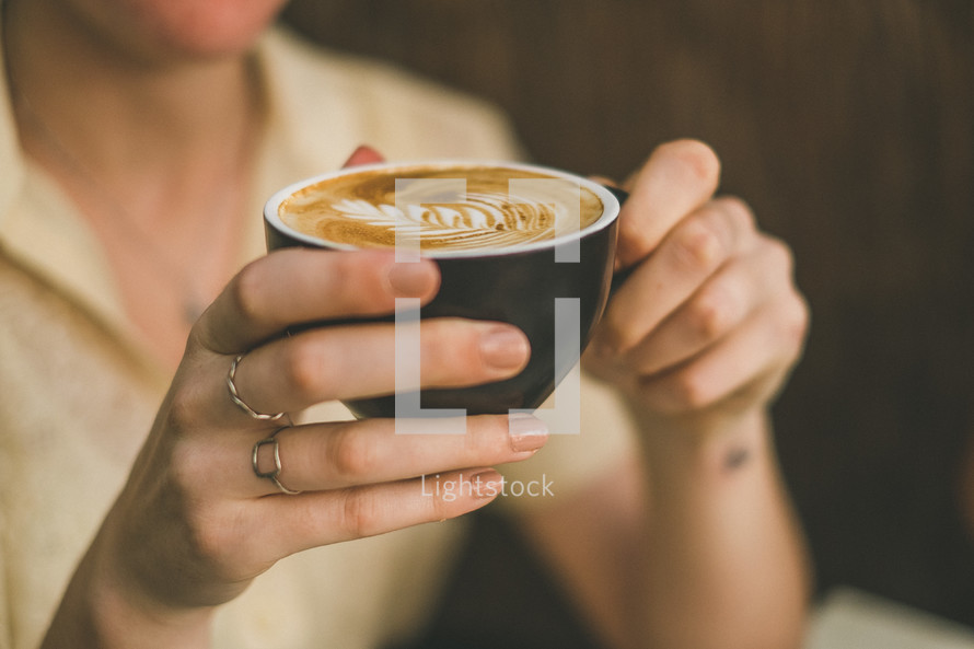 woman holding a cup of cappuccino 