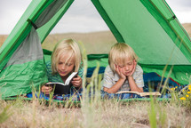 children reading Bibles in a tent 