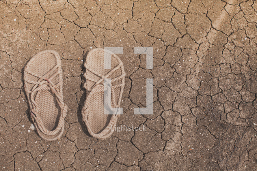 Rope sandals on the dry, cracked earth.