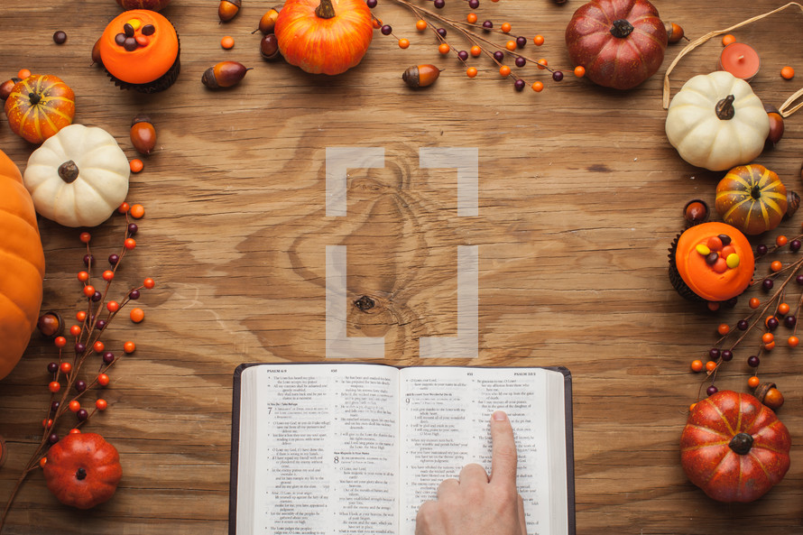 finger pointing to Bible scripture surrounded by fall themed decorations 