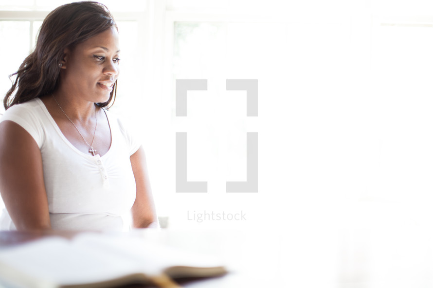 woman deep in thought and an open Bible