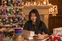 an Asian woman wrapping Christmas gifts 