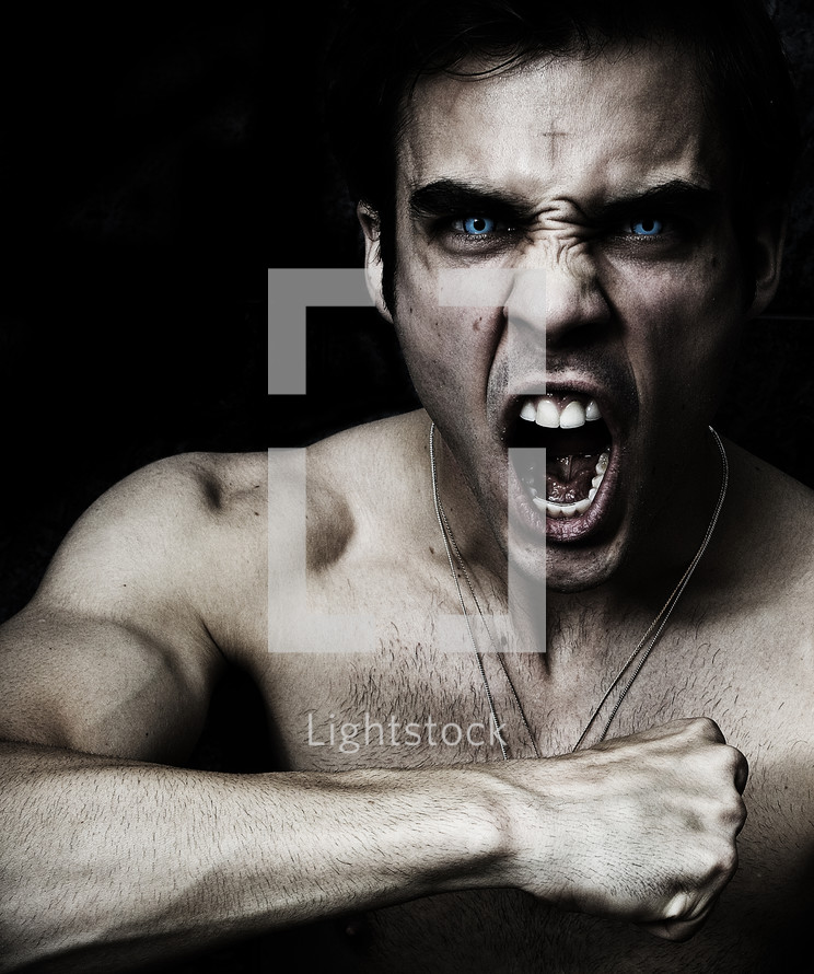 Adam Virtue; man yelling with piercing, brilliant blue eyes and cross on forehead.