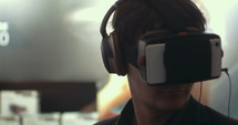 Close-up shot of a man in headphones getting experience in using VR-headset. Augmented reality device creating virtual space for smartphone applications