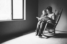 mother reading to her son sitting in a rocking chair 