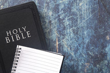 Bible and notebook on a blue grunge background 