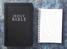 notebook and Bible on a blue grunge background 