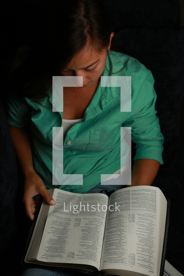 teen girl reading a bible on her lap