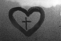 water droplets on glass and heart with cross 