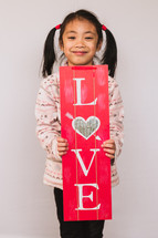 A child holding a love sign 
