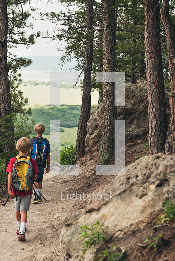 boys hiking on a path in a forest 