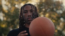 Portrait of a smiling young man playing basketball on a sunny day